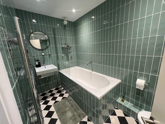 Green-tiled bathroom with walk-in shower