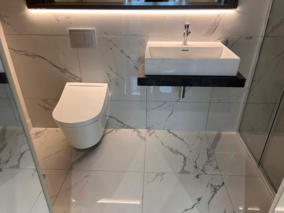 Marble-tiled bathroom with wall-hung WC