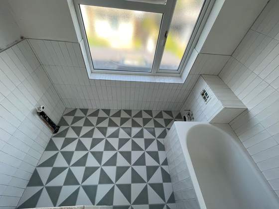 Bathroom with skylight and geometric floor tiles