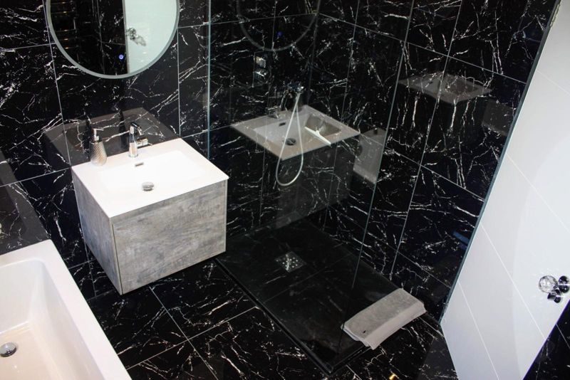 Black marble-effect bathroom with concrete-look vanity and walk-in shower