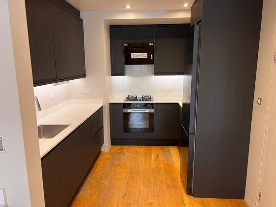 Dark handleless kitchen with oak flooring