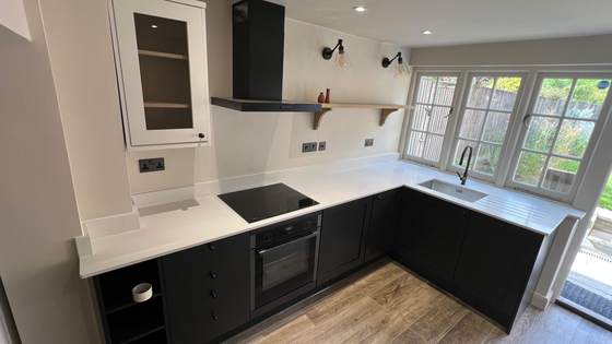 L-shaped dark kitchen with integrated appliances