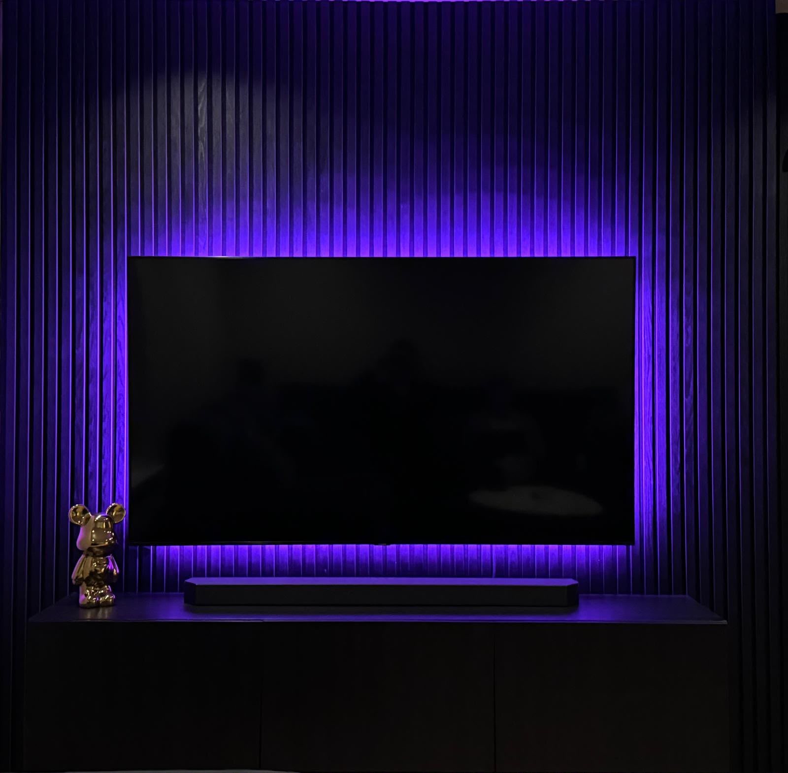 Fluted-panel media wall with purple LED backlighting, by CVS Renovations
